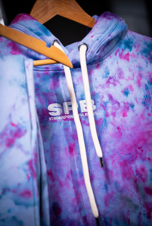 Purple Rain tie-dye hoodie with 'SPP' logo on a hanger