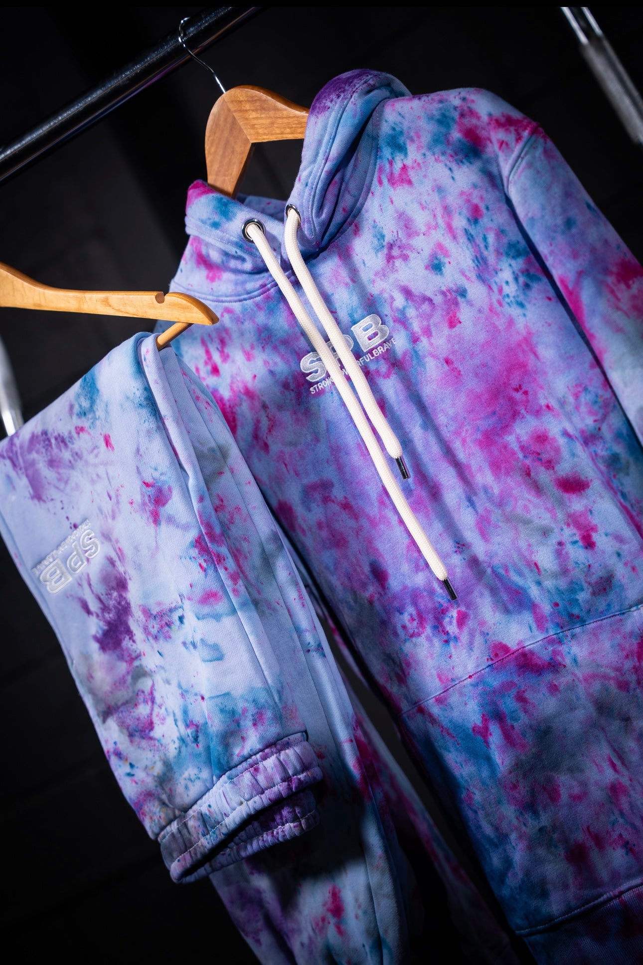 Purple rain tie-dye set on a hanger against a dark background